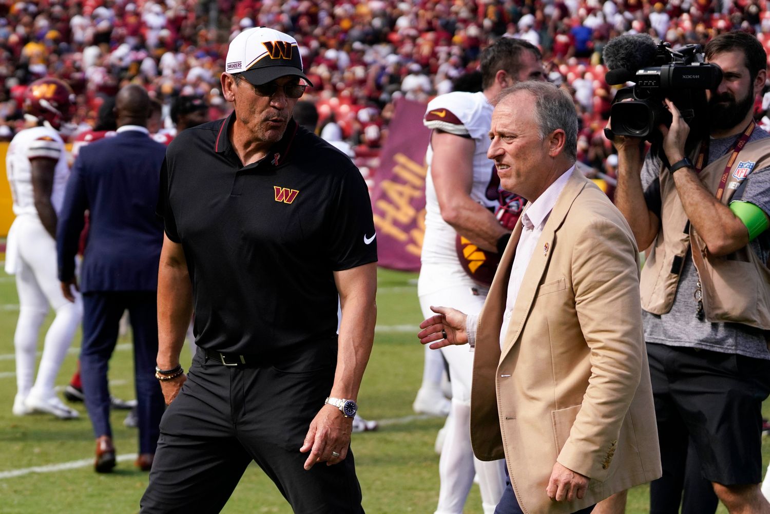 Washington Commanders head coach walks with Washington Commanders managing partner Josh Harris following the Commanders victory over the Arizona Cardinals at FedExField.
